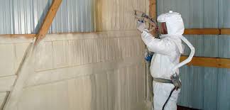 a man spraying foam to insulate a shipping container